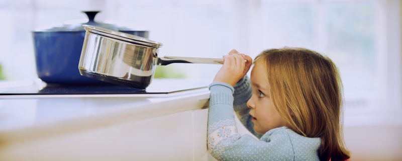 Young Girl Risking Accident With Pan In Kitchen